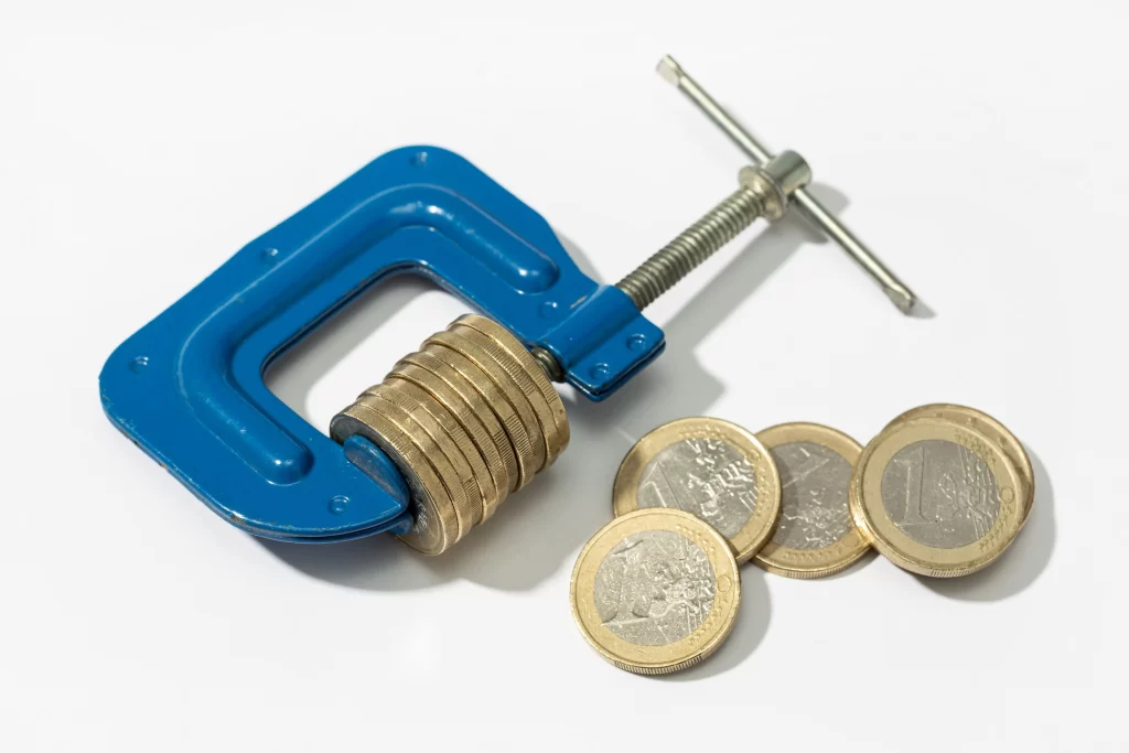 Monedas siendo apretadas por una mordaza