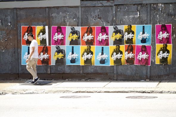Muchos stickers de colores pegados en la pared de una calle