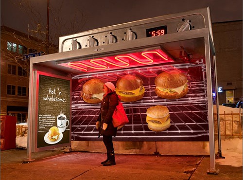 Una parada de bus en forma de un horno eléctrico que está calentando hamburguesas